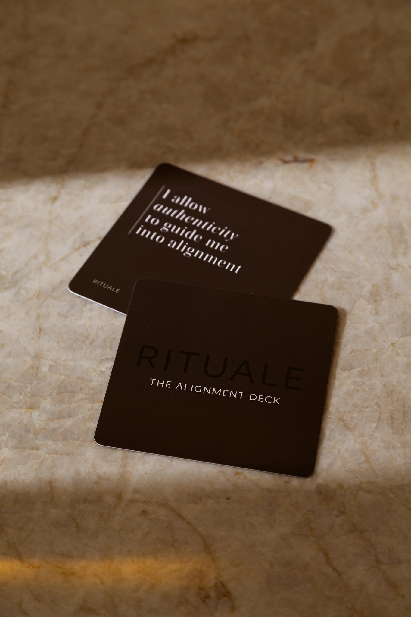 Two Rituale Alignment Deck cards on marble surface showing affirmation and deck title