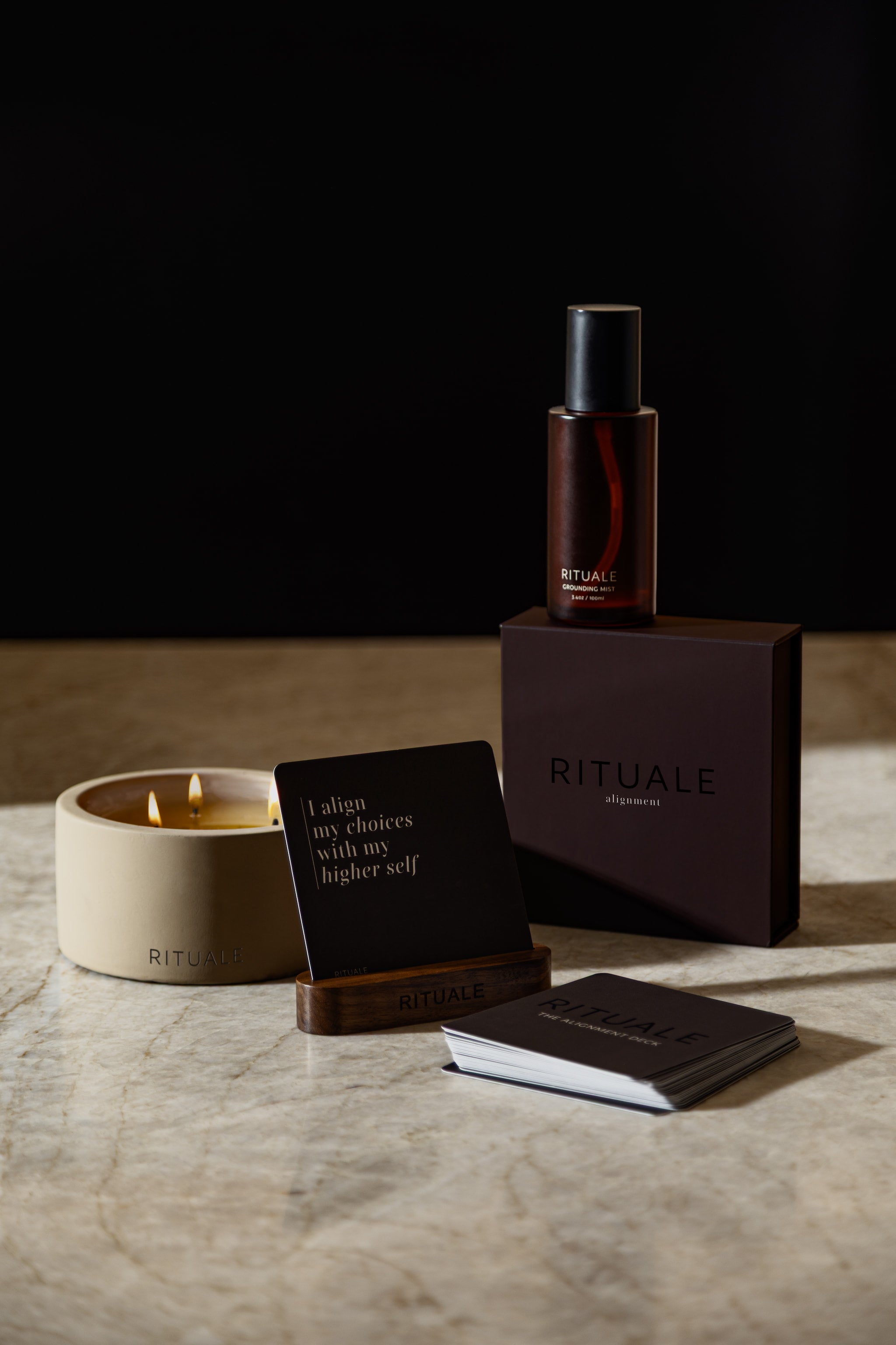 RITUALE Grounding Mist, Alignment Deck, and Concrete Candle displayed together on marble.